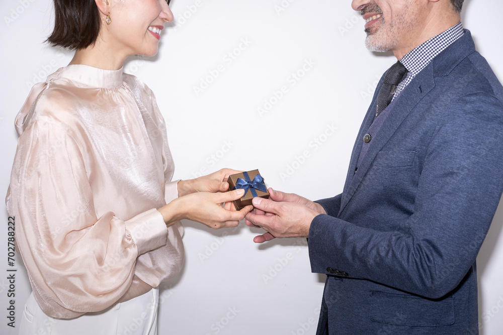 女性にプレゼントを渡している男性/スタジオ撮影白背景 女性にプレゼントを渡している男性/スタジオ撮影白背景