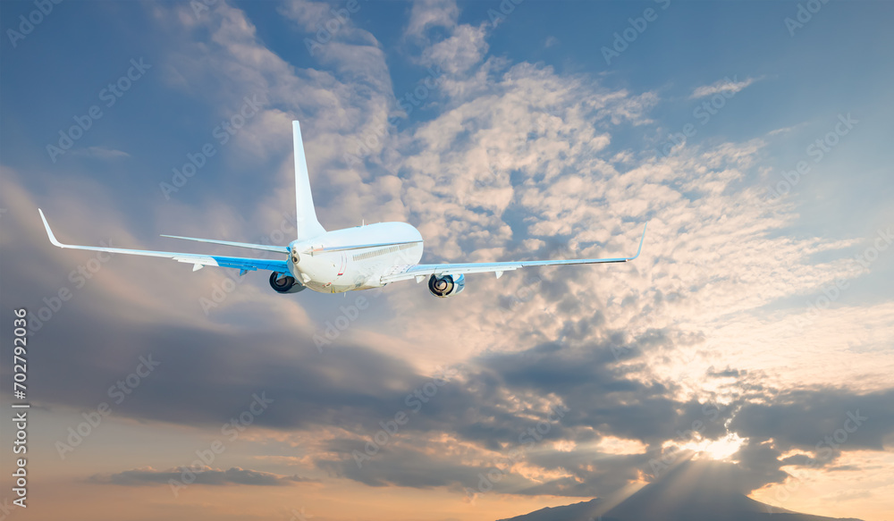 Airplane flying over tropical sea at sunset Airplane flying over tropical sea at sunset