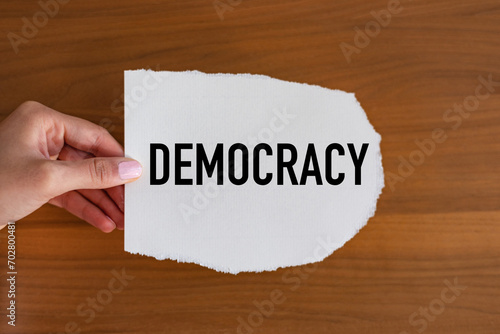 Democracy. Woman hand holds a piece of paper with a note, democracy. Republic, sovereign, autonomy, politics, human rights, politics. photo