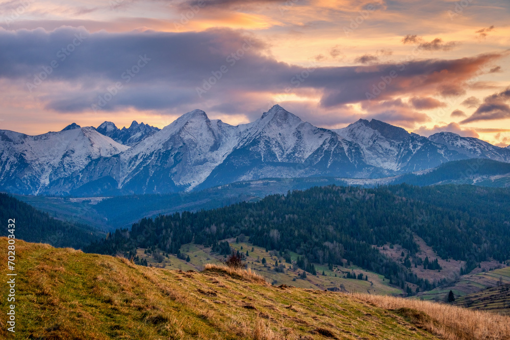 Fototapeta premium Autumn mountains landscape. Beautiful autumn with trees under the Tatra Mountains at sunrise. Sun moutain forest fog landscape at sunset on meadow.