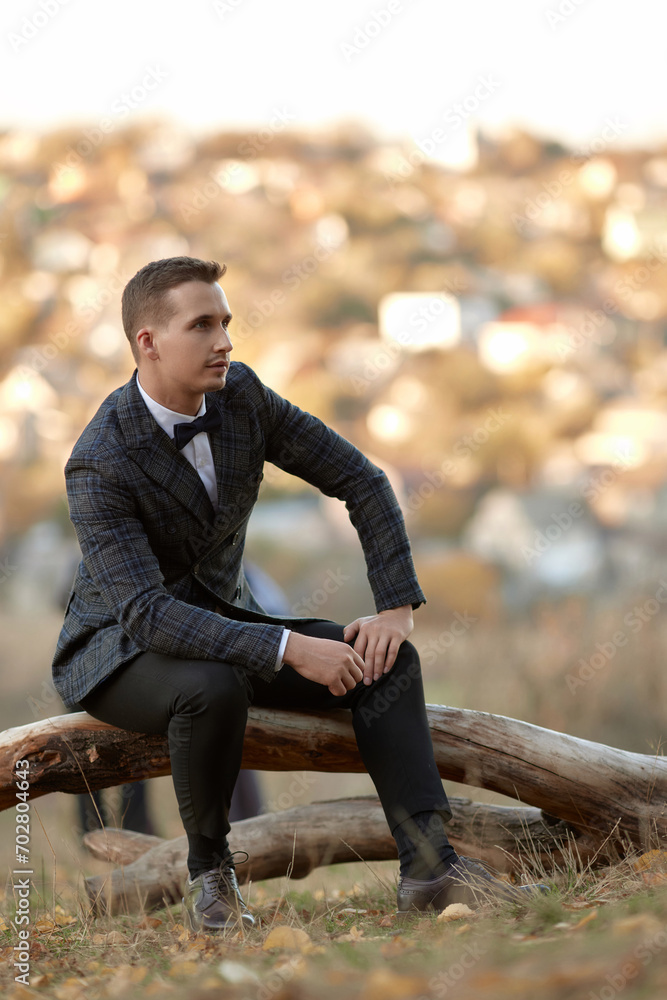 Fototapeta premium Handsome young man in classic checked suit outdoor