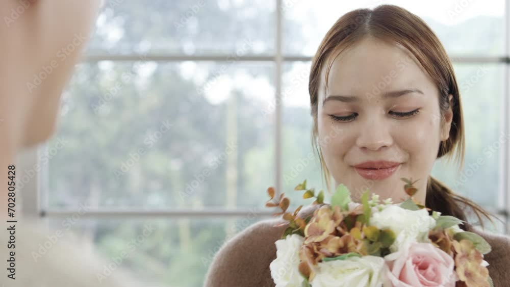 Asian young man surprising his beautiful girlfriend with bouquet of flowers at home, Attractive romantic new marriage couple male and woman spend time to celebrate anniversary and valentine's day Asian young man surprising his beautiful girlfriend with bouquet of flowers at home, Attractive romantic new marriage couple male and woman spend time to celebrate anniversary and valentine's day