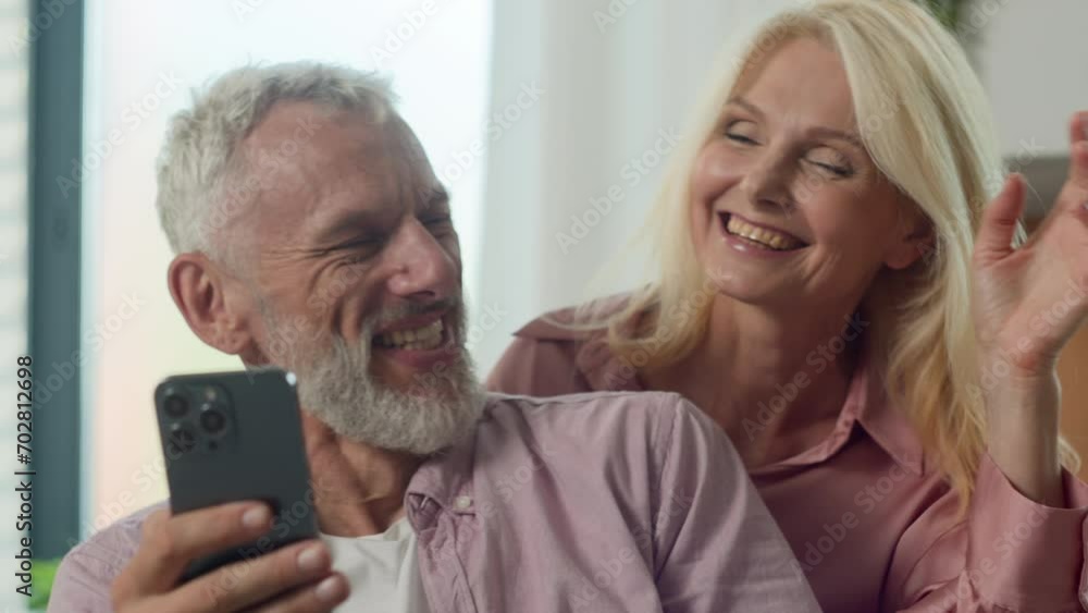 Laughing smiling Caucasian happy family couple man woman grandmother grandfather talking via video call on phone using mobile application communicate at online conference remote meeting via smartphone Laughing smiling Caucasian happy family couple man woman grandmother grandfather talking via video call on phone using mobile application communicate at online conference remote meeting via smartphone