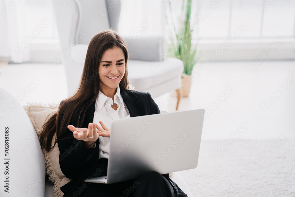 Smiling businesswoman engaging in a video call on her laptop at home Smiling businesswoman engaging in a video call on her laptop at home