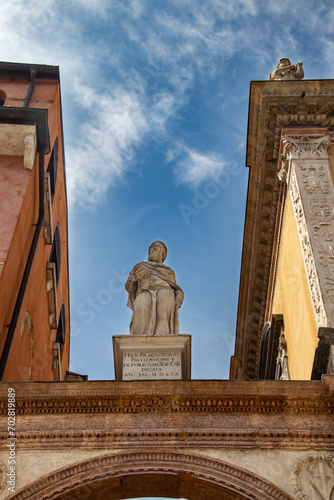 Statue of Dante Alighieri in piazza dei Signori to Verona in Italy. Springtime and holidaytime. Travel destination. White marble statue on a pedestal. Symbol of the italian culture. photo