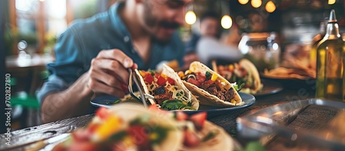 Hungry latin man eating delicious mexican tacos for dinner from the food cart. with copy space image. Place for adding text or design photo