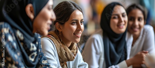 High angle of modern teacher and his immigrant students working on educational English language poster together in group. with copy space image. Place for adding text or design photo