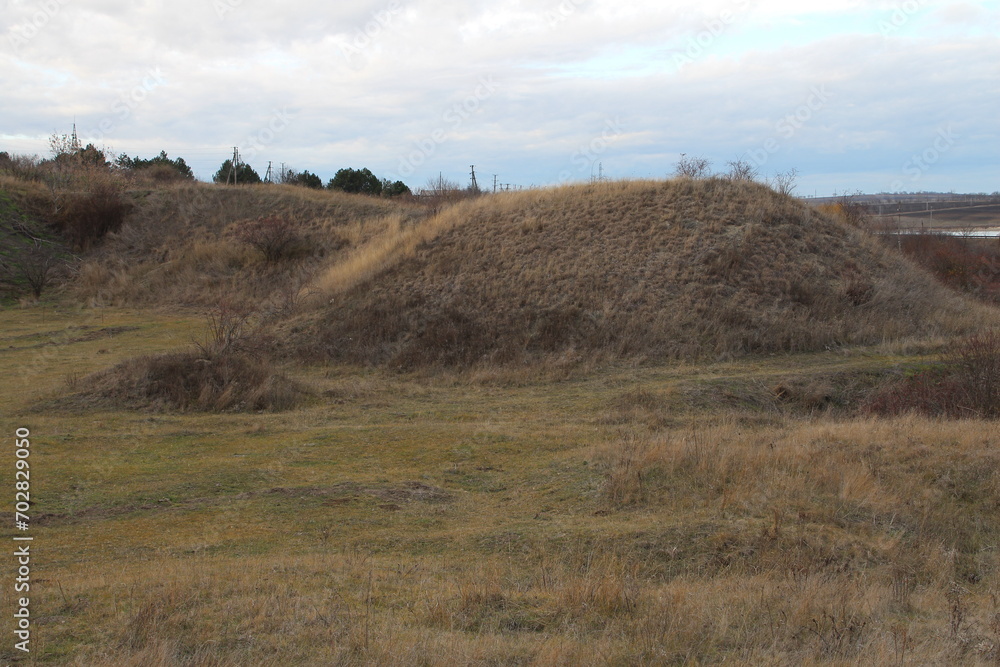 A grassy hill with a fence in the middle