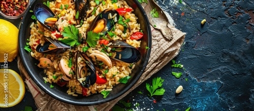 Mediterranean dish risotto pilaf with mussels in a plate with lemon slices and parsley close up Italian Greek Moroccan cuisine. with copy space image. Place for adding text or design