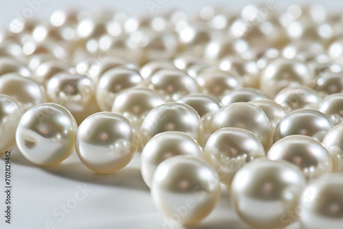 A close-up of scattered, lustrous white pearls on a bright surface, suitable for luxury or jewelry concepts