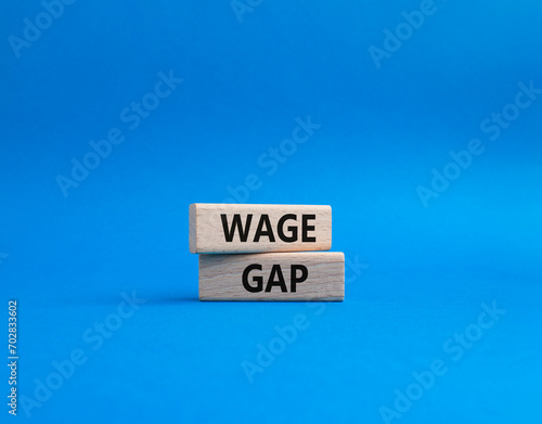 Wage Gap symbol. Concept words Wage Gap on wooden blocks. Beautiful blue background. Business and Wage Gap concept. Copy space.