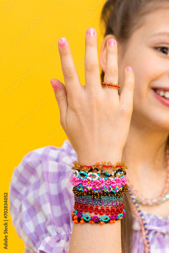 Beaded bracelets on the hands of a little girl. Multicolored jewelry on his hands. Beading for children. Beaded bracelets on the hands of a little girl. Multicolored jewelry on his hands. Beading for children.