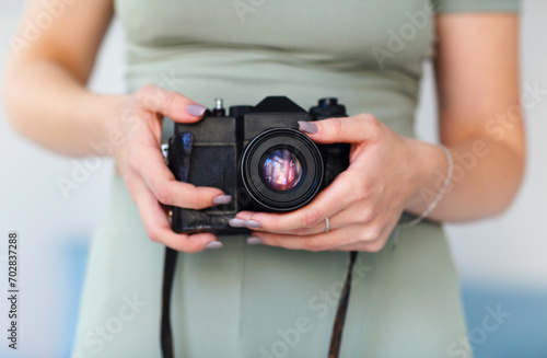 Young woman photographer taking photo picture with camera indoors. Close up © Dasha Petrenko