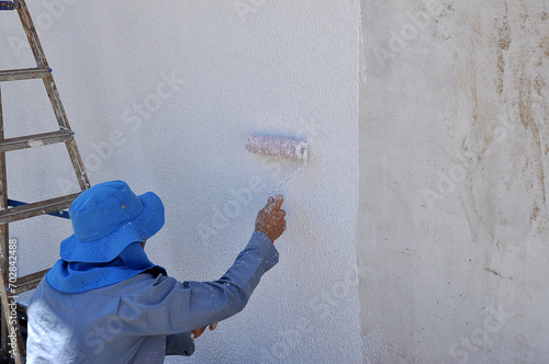 pintor trabalhando em pintura de casa  photo