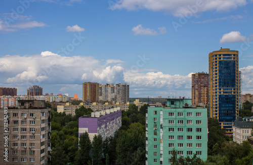 A residential area with modern multi-storey buildings among green trees in Reutov, Moscow region on a sunny summer day and a space for copying
