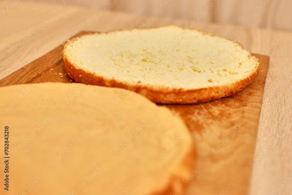 A freshly baked cake is cut in half. Cooking a festive pie at home A freshly baked cake is cut in half. Cooking a festive pie at home