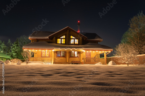 Wooden house with beautiful New Year's lighting at night