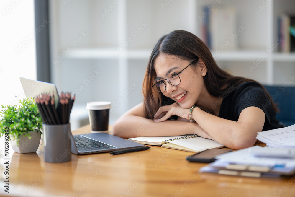 Freelance Asian businessperson, businesswoman sitting collapsed on her arms in a good mood, taking a nice break from work. Freelance Asian businessperson, businesswoman sitting collapsed on her arms in a good mood, taking a nice break from work.