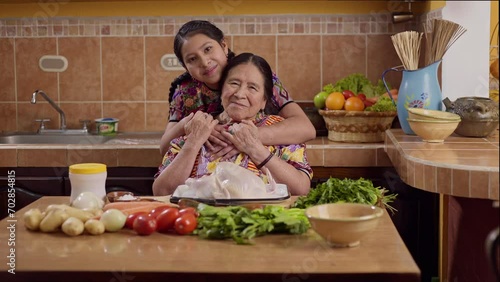Retrato de abuela y nieta de la etnia Maya en la cocina de su hogar, luciendo sus trajes típicos que las identifican como representantes de la etnia Maya. photo