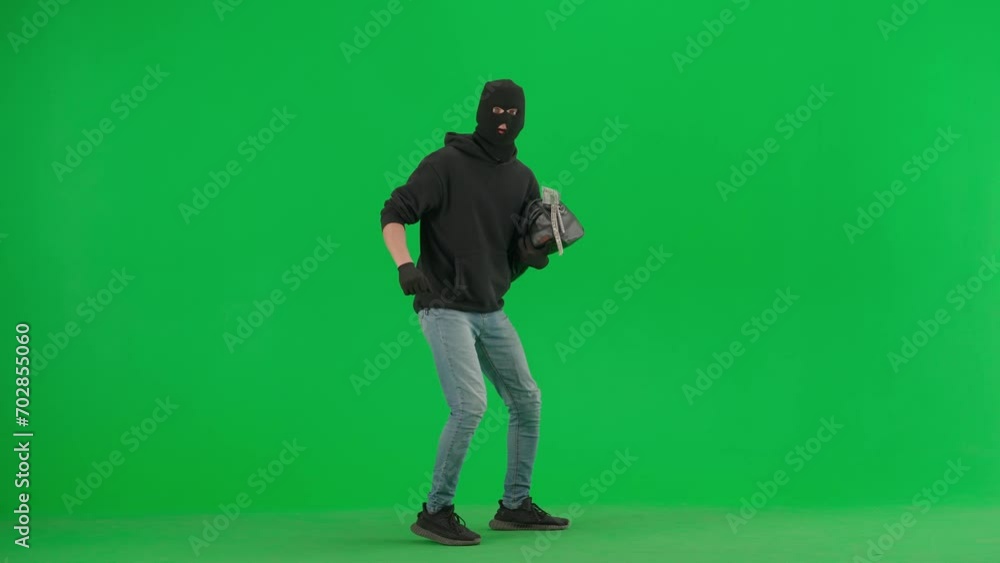 Portrait of thief on chroma key green screen background. Man robber with stolen bag walks, got caught up, standing on knees holding hands up. Portrait of thief on chroma key green screen background. Man robber with stolen bag walks, got caught up, standing on knees holding hands up.