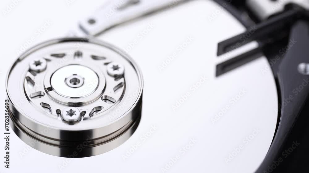 Hard drive isolated on white background. HDD. Major components of a 3.5-inch SATA hard disk drive: platter, spindle, actuator, actuator arm. Disk head above the plates Hard drive isolated on white background. HDD. Major components of a 3.5-inch SATA hard disk drive: platter, spindle, actuator, actuator arm. Disk head above the plates