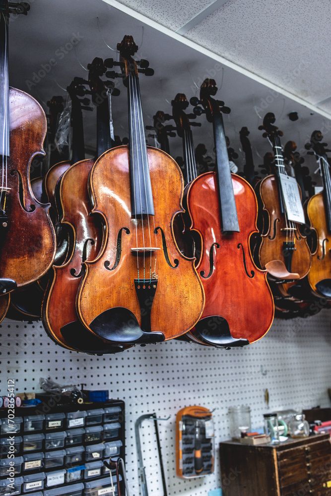 Naklejka premium violins are handing in a shop ready for finishing