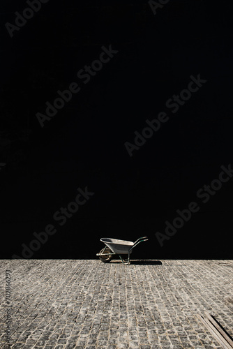 Vertical shot of wheelbarrow on a dark background at the construction site