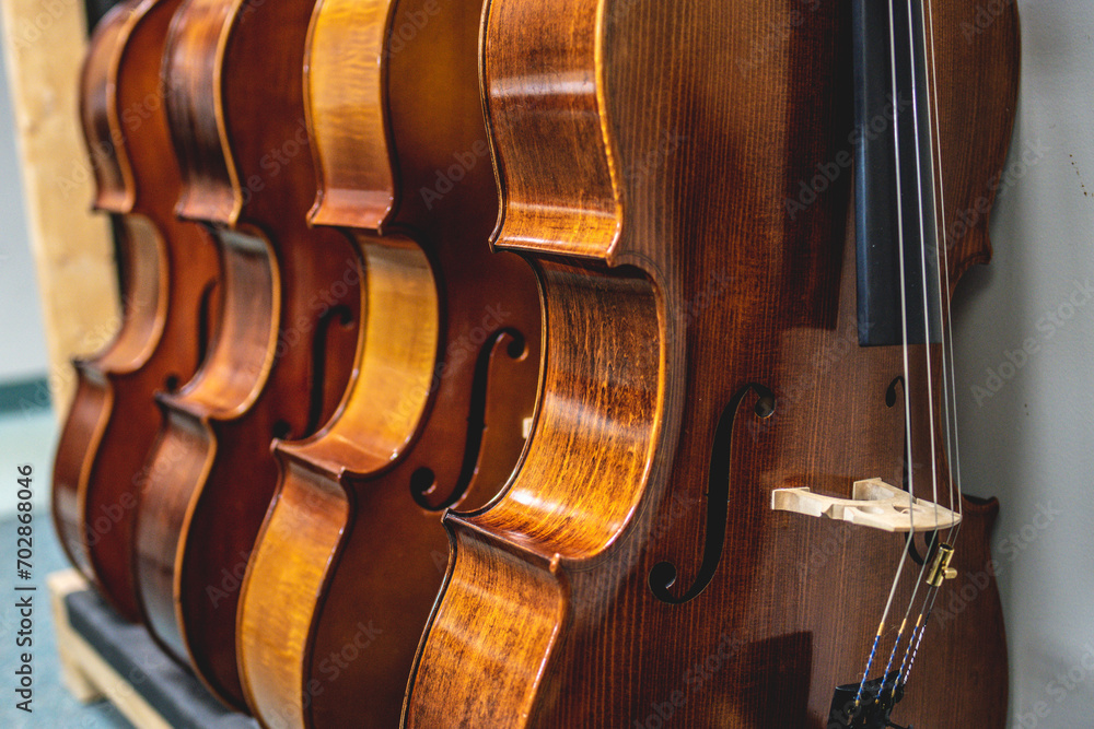Row of multiple violins hanging on the wall, musician workshop Row of multiple violins hanging on the wall, musician workshop