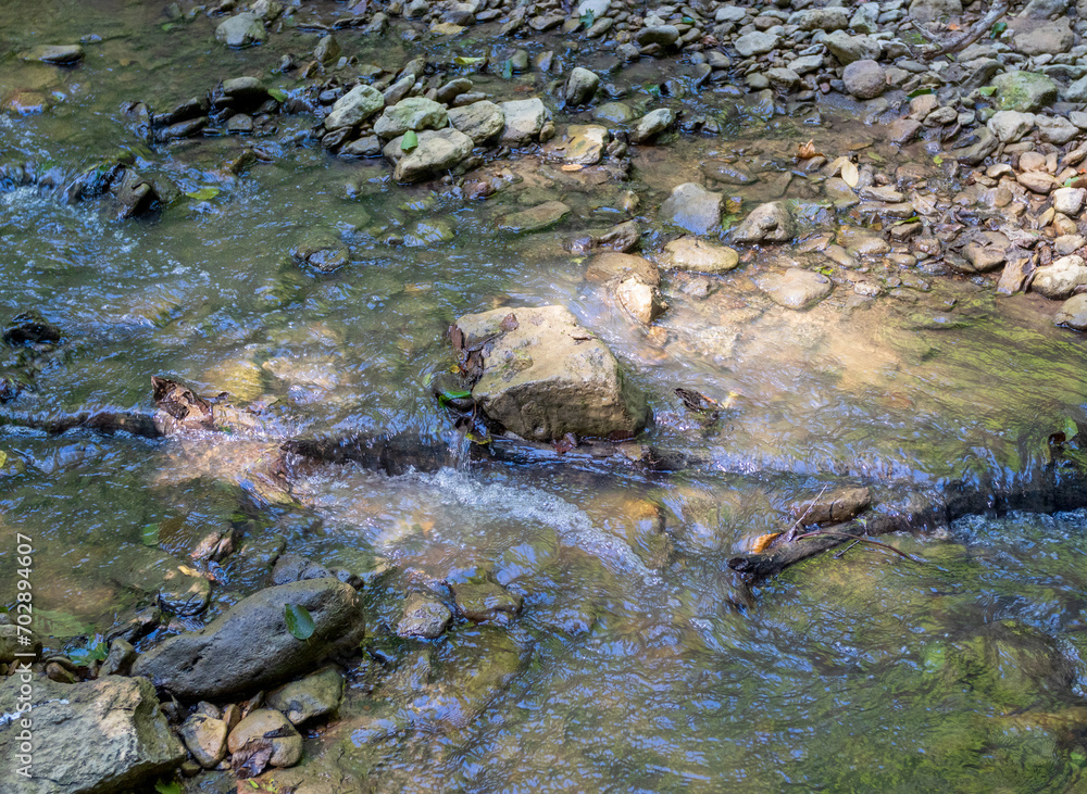 A shallow riverbed with a rocky bottom and shoals and fragments of stones