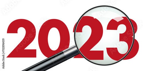 Concept de présentation d’un bilan d’entreprise pour l’année 2023 qui est vu au travers d’une loupe pour symboliser le travail d’analyse.