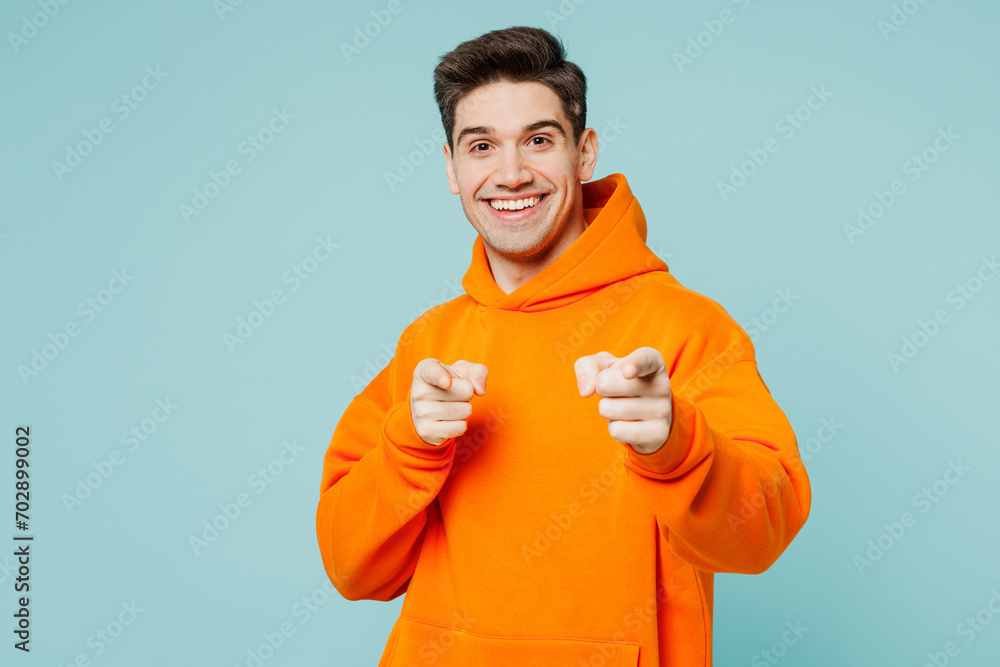 Young fun man he wears orange hoody casual clothes point index finger camera on you motivating encourage isolated on plain pastel light blue cyan color background studio portrait. Lifestyle concept. Young fun man he wears orange hoody casual clothes point index finger camera on you motivating encourage isolated on plain pastel light blue cyan color background studio portrait. Lifestyle concept.