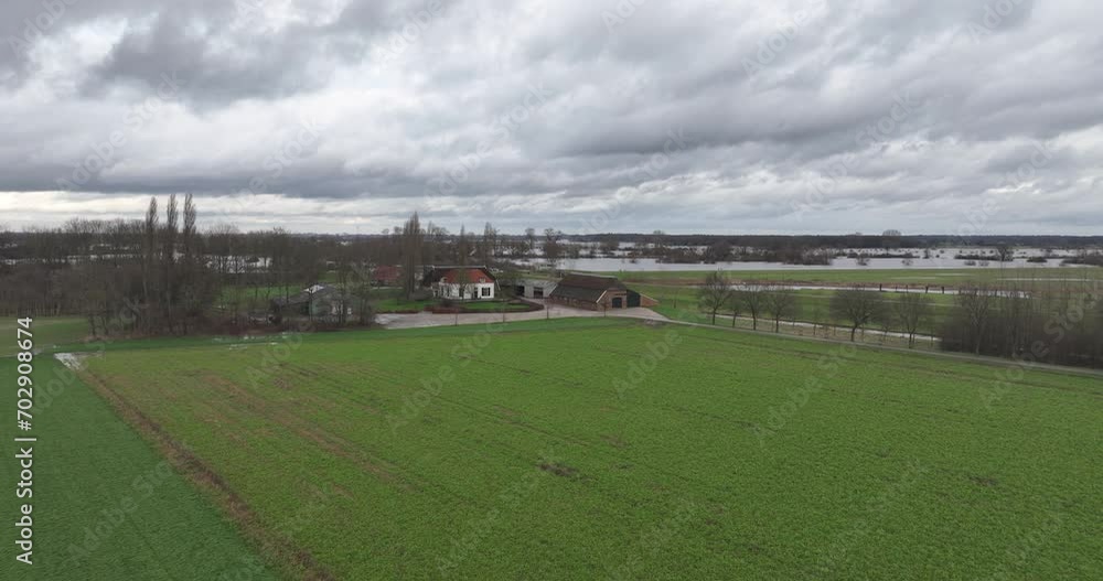 Rising aerial shot of river overflowing, flooding and farm houses at danger. Rising aerial shot of river overflowing, flooding and farm houses at danger.
