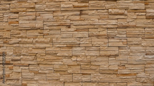finishing with natural stone in the form of layered tiles in brown shades, a fragment of the texture of a stone exterior surface, a stone background like copy space