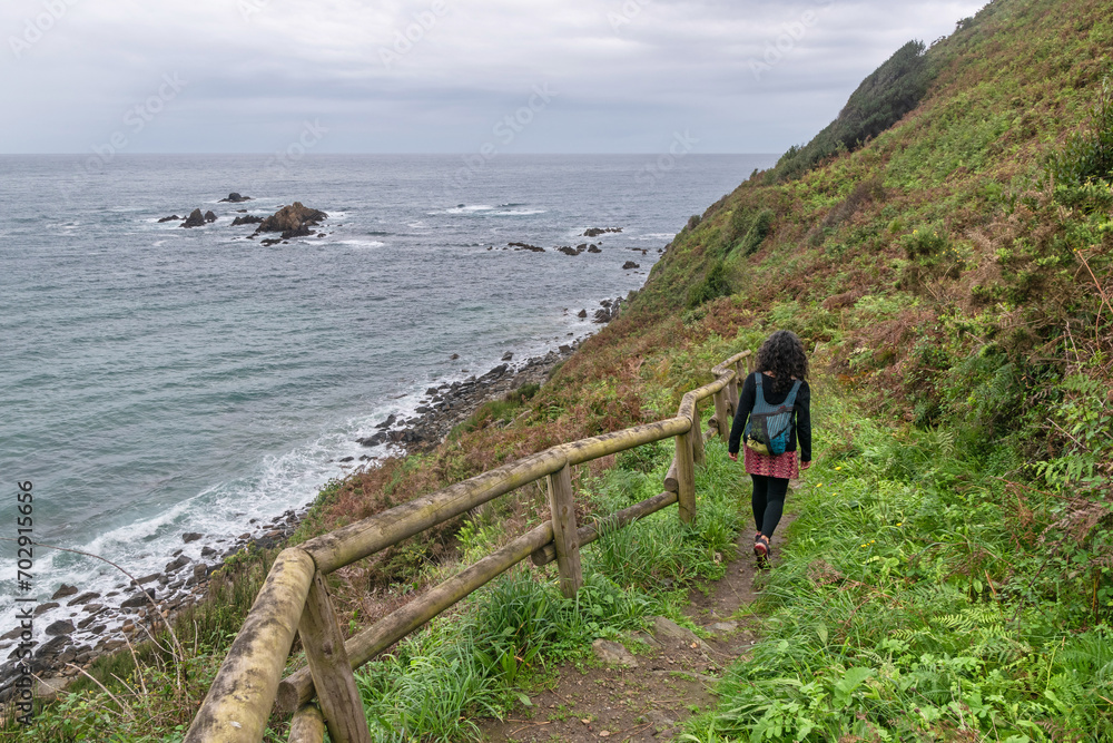 Woman walking along the Asturian Coast. Muros de Nalón