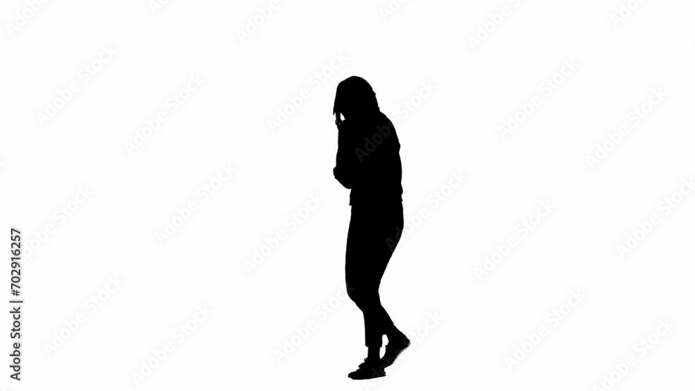Black silhouette of a woman on a white isolated background. A young girl walks, looking around frightened, fleeing faster from danger. Half turn. Black silhouette of a woman on a white isolated background. A young girl walks, looking around frightened, fleeing faster from danger. Half turn.