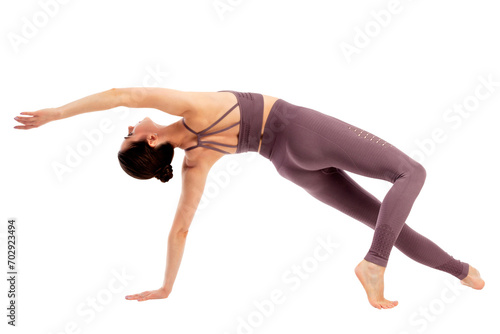 Young beautiful yoga sports woman is posing in studio, isolated