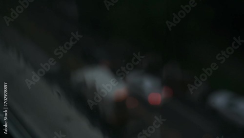 Closeup of rain falling against a window during a heavy rainstorm (ID: 702928897)