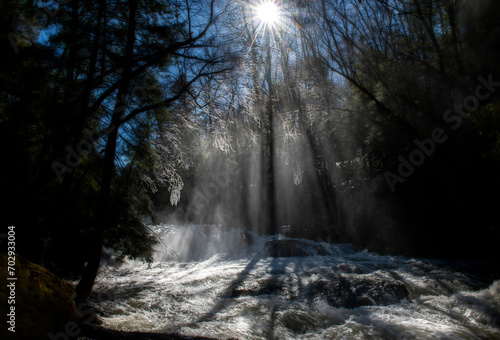 Sun shining on fast moving stream on a cold morning