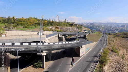 Time-lapse panorama featuring Victory Park with a Ferris wheel, road complex along Saralanj Avenue, and bustling traffic on a clear, sunny day in Yerevan, Armenia, uhd, 4k, 3840, 2160 photo