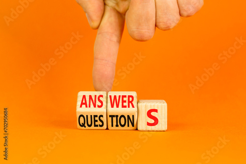 Q and A questions and answers symbol. Turned wooden cubes and changed the word questions to answers. Beautiful orange background, copy space. Business Q and A questions and answers concept.