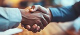Close-up handshake showing trust between diverse business partners finalizing a contract for mergers and acquisitions at an office desk.