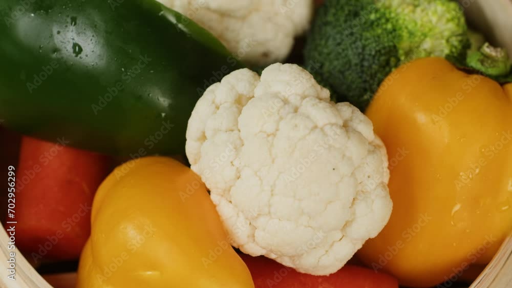 Steaming vegetables close-up. Wooden steamer for cooking.The concept of food and healthy eating. Yellow and green pepper, broccoli, carrot,cauliflower Steaming vegetables close-up. Wooden steamer for cooking.The concept of food and healthy eating. Yellow and green pepper, broccoli, carrot,cauliflower