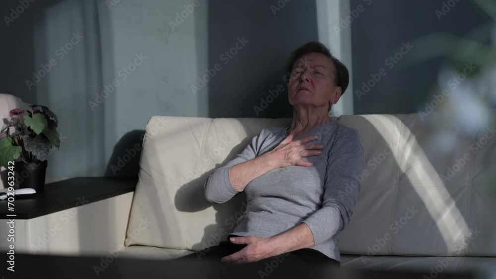 Attack and exacerbation of the disease in an old woman sitting on the sofa at home Attack and exacerbation of the disease in an old woman sitting on the sofa at home