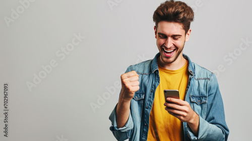 Man smiling and looking at his smartphone, which he holds in his hands.