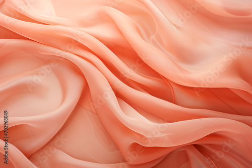 Texture of draped fabric of peach color. Beautiful emerald peach fuzz soft silk textile. Design for texture, background, wallpaper.