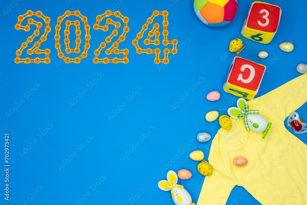 Obraz premium Baby onesie romper bodysuit product mockup with Baby Pacifier, Teddy bears, socks and various toys and 2024 Happy New Year made from golden chain links