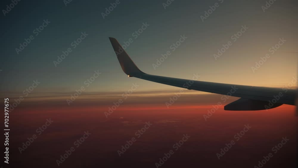 Wing and sunset sky, View from the airplane porthole on sunset time Wing and sunset sky, View from the airplane porthole on sunset time