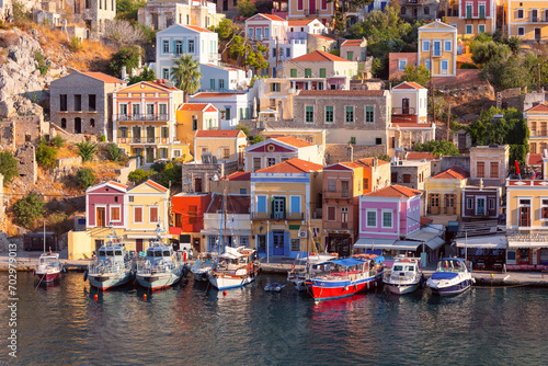 Multi-colored facades of houses in the village of Symi at sunset.