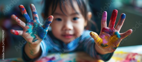 Creative Asian child with painted hands  discovering at home  nurturing their education.