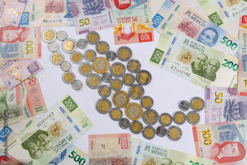 new bank notes of mexican peso and shape of Mexico made with coins background. 20, 50, 100, 200, 500 pesos